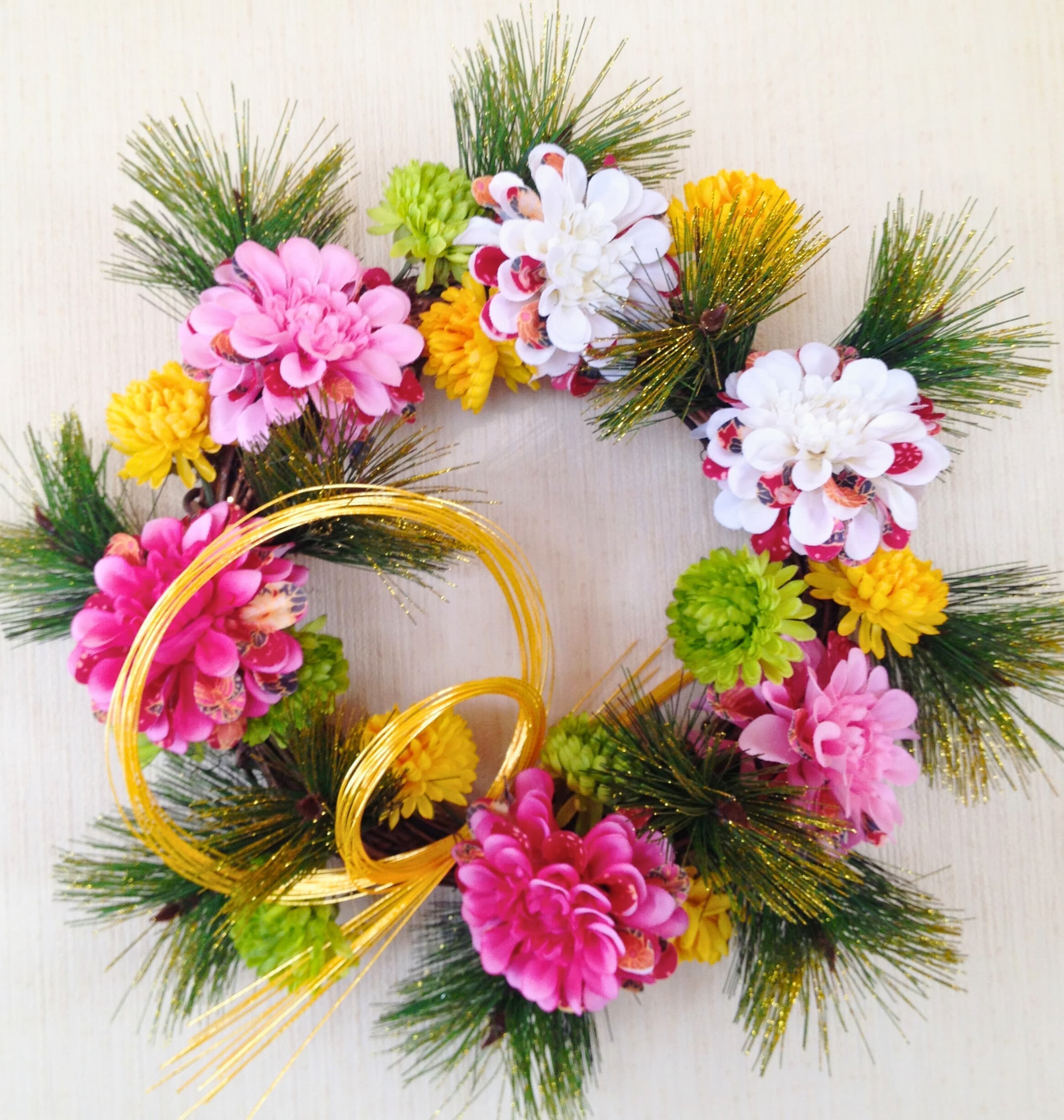黄色とピンクがかわいらしくも華やかなお正月リース