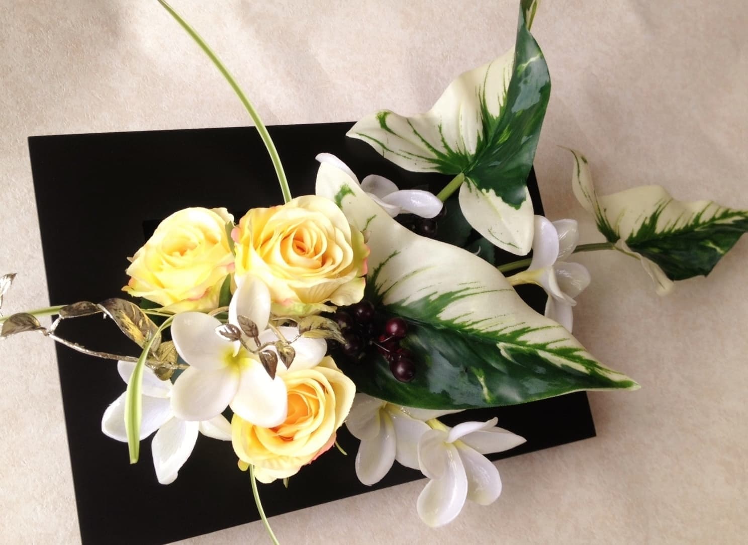 壁に掛けることができるアレンジメントです。黄色と白、グリーンがさわやかな組み合わせです。